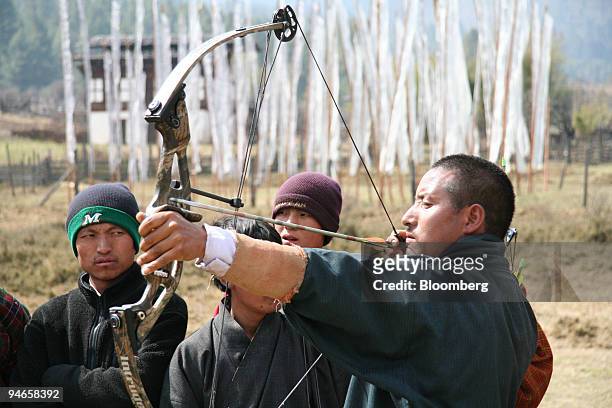 An archer works his bow and arrow in Gangtey, Bhutan, against a backdrop of prayer flags on Wednesday, March 8, 2006. "Turn right at Mrs. Smith's...