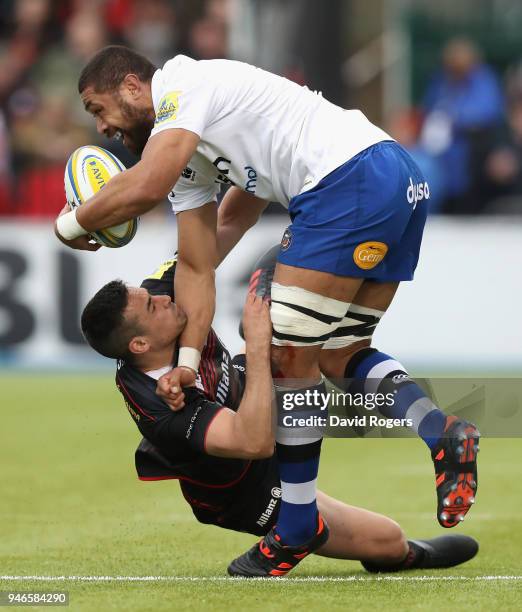 Taulupe Faletau of Bath is tackled by Alex Lozowski during the Aviva Premiership match between Saracens and Bath Rugby at Allianz Park on April 15,...