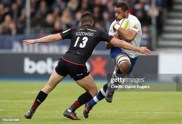 Taulupe Faletau of Bath is tackled by Alex Lozowski during the Aviva Premiership match between Saracens and Bath Rugby at Allianz Park on April 15,...