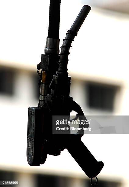Fuel nozzle gun hangs from the ceiling at a gas station in Mumbai, India, on Thursday, Nov. 29, 2007. India's economy grew last quarter at the...