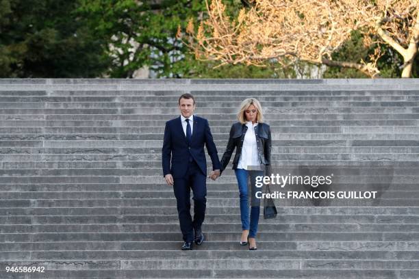 French President Emmanuel Macron arrives with his wife Brigitte Macron to attend an interview with journalists from BFM television and the Mediapart...