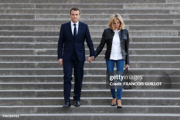 French President Emmanuel Macron arrives with his wife Brigitte Macron to attend an interview with journalists from BFM television and the Mediapart...