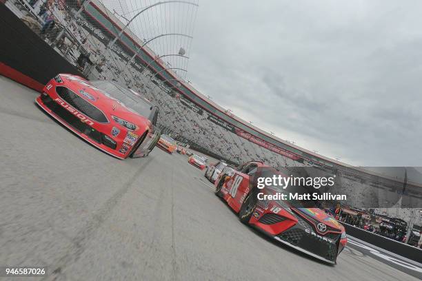 Kyle Busch, driver of the Skittles Toyota, and Kurt Busch, driver of the Haas Automation/Monster Energy Ford, take a pace lap prior to the start of...