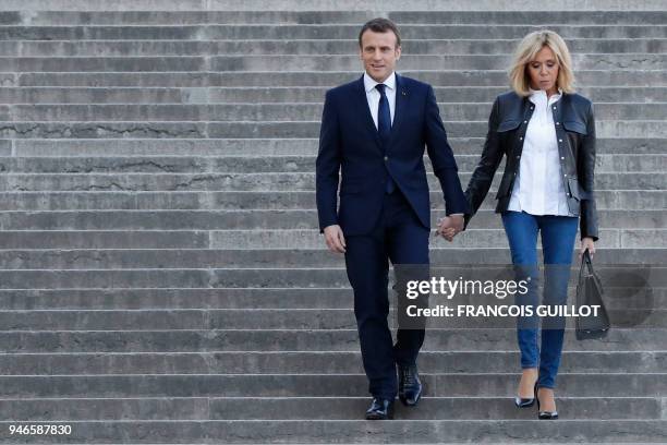 French President Emmanuel Macron arrives with his wife Brigitte Macron to attend an interview with journalists from BFM television and the Mediapart...