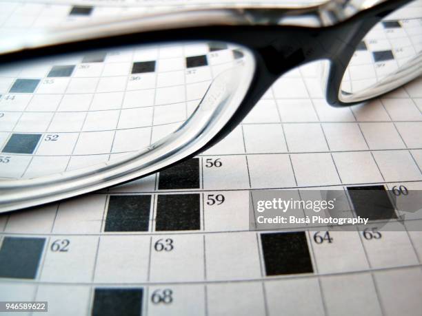 black eyeglasses on crossword puzzle - jogo de palavras imagens e fotografias de stock