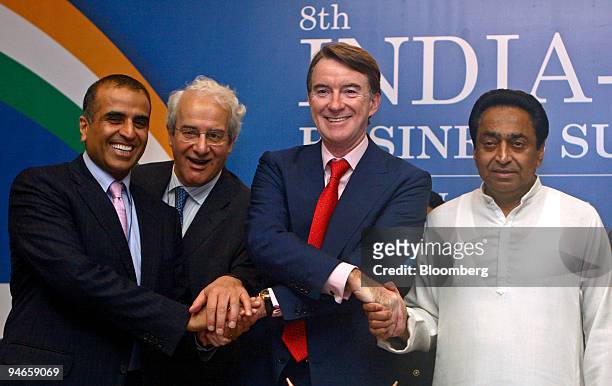 Peter Mandelson, third from left, shakes hands with Sunil Bharti Mittal, chairman of Bharti Airtel Ltd., left, Philippe de Buck, secretary of...