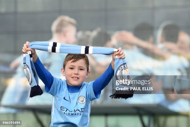 City fan, seven year old Bobby English poses on his father's shoulders as Manchester City supporters gather outside the Etihad Stadium in Manchester,...