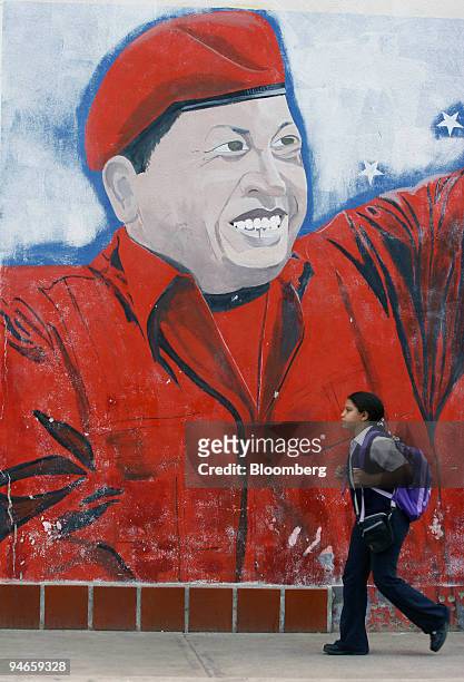 Student walks by a mural of Venezuelan President Hugo Chavez in Caracas, Venezuela, November 24, 2006. Chavez leads opponent Manuel Rosales by 32...
