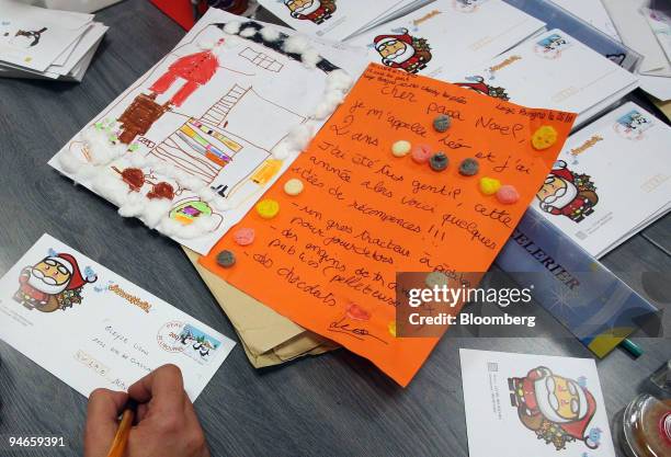 Postal worker replies to a letter addressed to Santa Claus at the La Poste office in Libourne, in the Bordeaux region of France, on Wednesday, Nov....