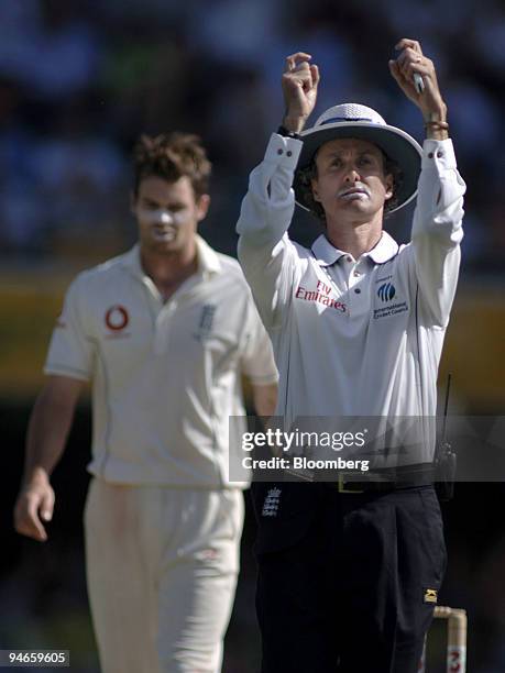 Umpire Billy Bowden, right, signals six runs as England bowler James Anderson walks back to his mark after being hit by Australia's batsman Stuart...