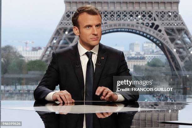 French President Emmanuel Macron poses on the TV set before an interview with RMC-BFM and Mediapart French journalists at the Theatre national de...