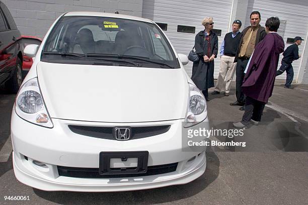 Car salesman Randy Grassi, second from right, talks with Erika Foin, far right, as her parents Ted and Angela Foin, stand in background while...