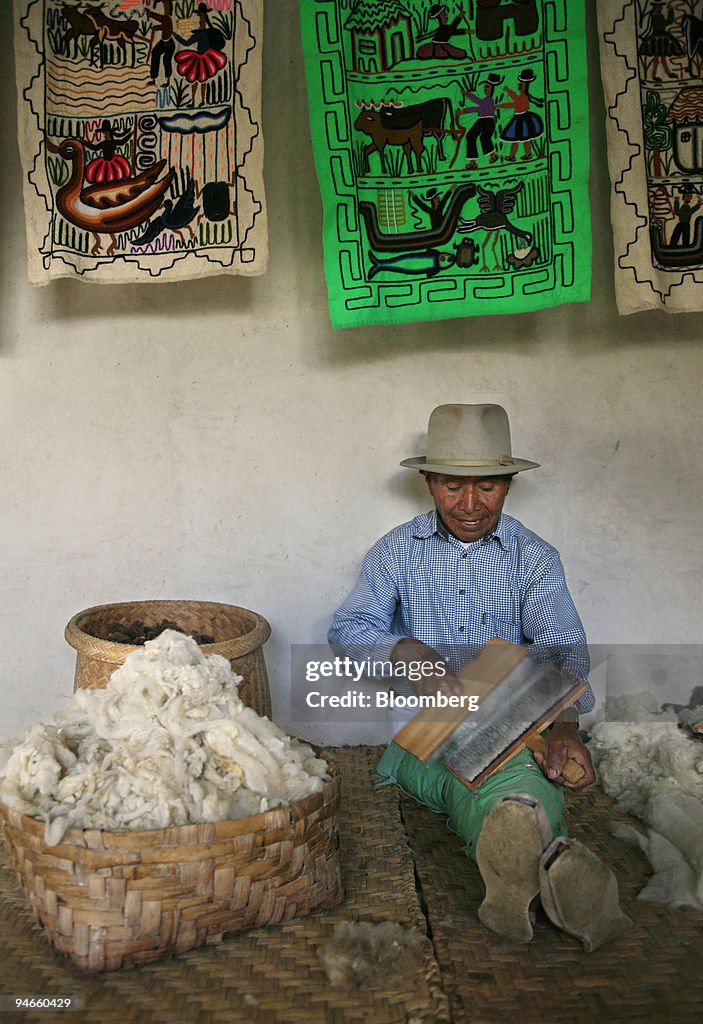 Jose Carlos de la Torre sits carding alpaca wool inside his