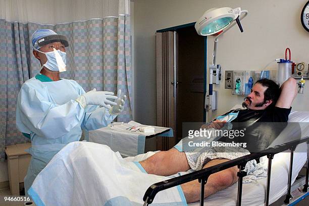 Doctor David Young prepares to lance a staph infection on the leg of George Crawford at San Francisco General Hospital September 18, 2006 in San...