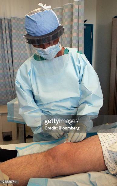 Doctor David Young lances a staph infection on the leg of George Crawford at San Francisco General Hospital September 18 in San Francisco, California.