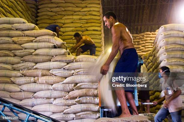 Workers belonging to Cooxupe , the largest private coffee cooperative in the world, move sacks of coffee in Guaxupe, Brazil, Tuesday, November 21,...