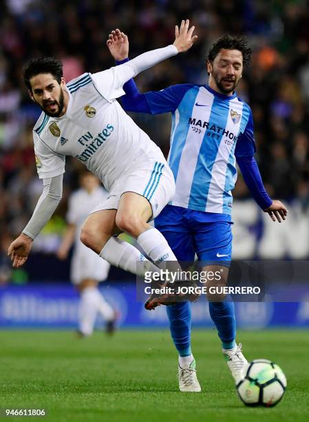 Real Madrid's Spanish midfielder Isco vies withy Malaga's Chilean midfielder Manuel Iturra during the Spanish league footbal match between Malaga CF...