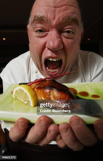 Mark Edwards, executive chef at Nobu, pretends to devour the famous miso black cod dish at the famed restaurant in London, U.K., on Tuesday, Nov. 27,...