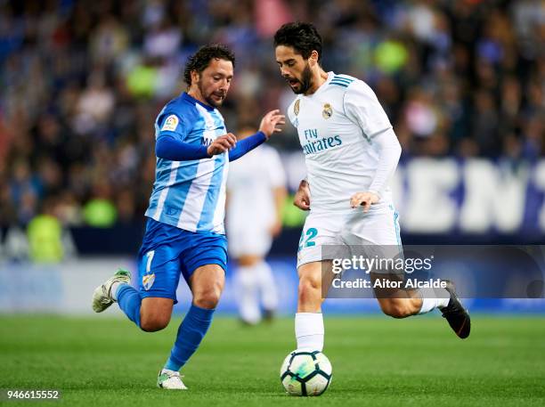 Isco Alarcon of Real Madrid competes for the ball with Manuel Rolando Iturra of Malaga during the La Liga match between Malaga CF and Real Madrid CF...