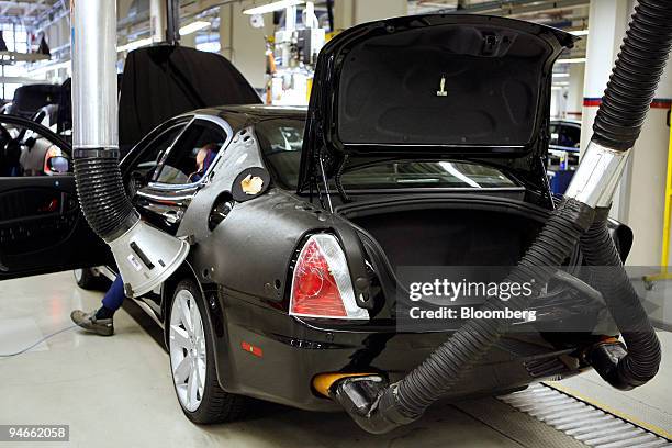 An employee tests the emissions output of a Maserati Quattroporte automobile in the Maserati factory's testing center in Modena, Italy, Tuesday,...
