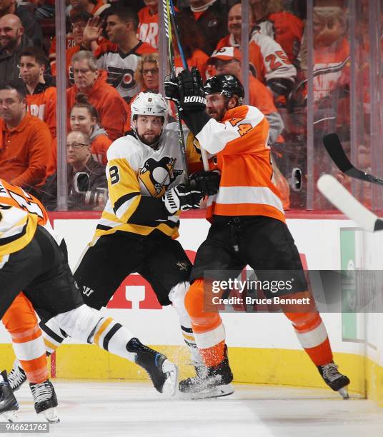 Brian Dumoulin of the Pittsburgh Penguins and Sean Couturier of the Philadelphia Flyers battle for position during the first period in Game Three of...