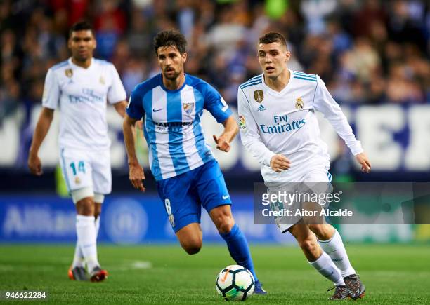 Mateo Kovacic of Real Madrid competes for the ball with Adrian Gonzalez of Malaga during the La Liga match between Malaga CF and Real Madrid CF at...