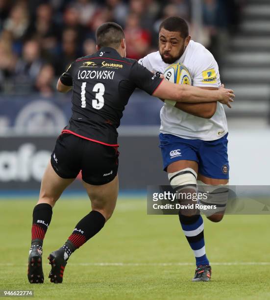 Taulupe Faletau of Bath is tackled by Alex Lozowski during the Aviva Premiership match between Saracens and Bath Rugby at Allianz Park on April 15,...