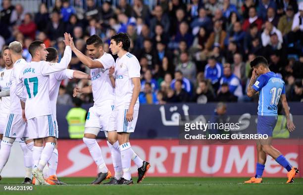 Real Madrid's Brazilian midfielder Casemiro celebrates a goal with teammates during the Spanish league footbal match between Malaga CF and Real...