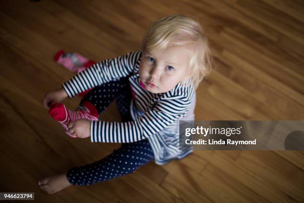 little girl trying to put on her socks - making choice stock pictures, royalty-free photos & images