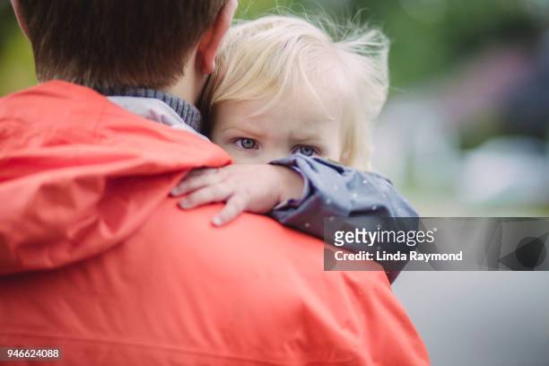 blue eyes of a little blond girl looking over daddy's shoulder - compassionate eye stock pictures, royalty-free photos & images