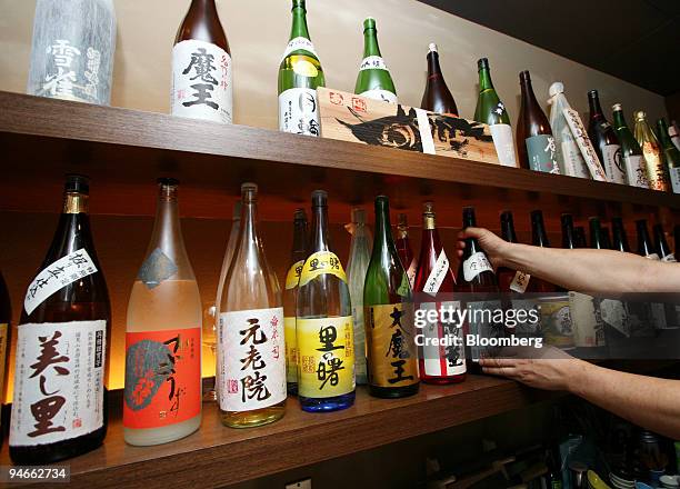 Bottles of Sake sit on a shelf at Restaurant Bange in Tokyo, Japan, on Sunday, Aug. 5, 2007. Between earthquakes, wartime bombing and Japan's...