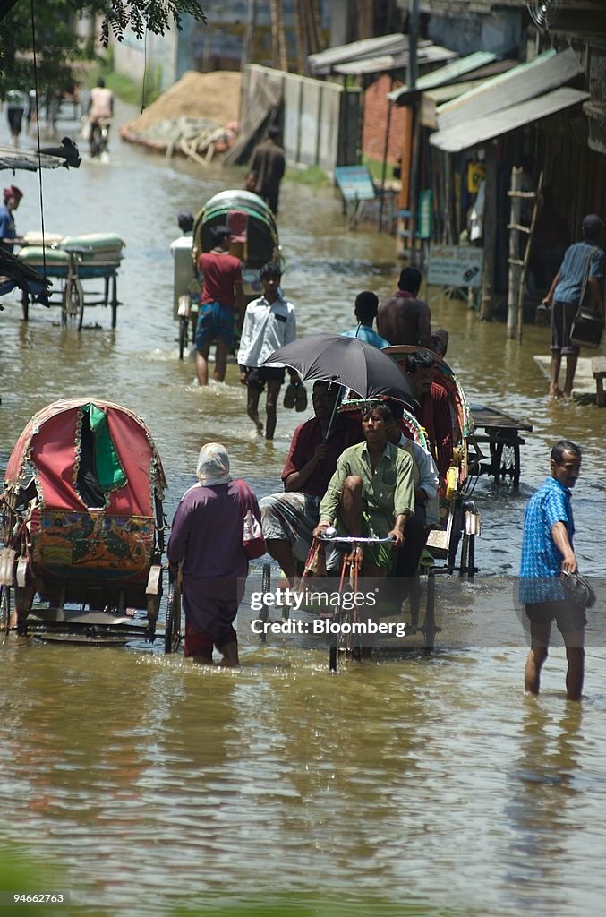 Rising waters flood a street in Demra on the outskirts of Dh