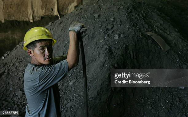 Worker pauses from shoveling coal in the Darkhan Metallurgical plant 220km north of Ulaanbaatar, Mongolia, Friday, September 15, 2006.