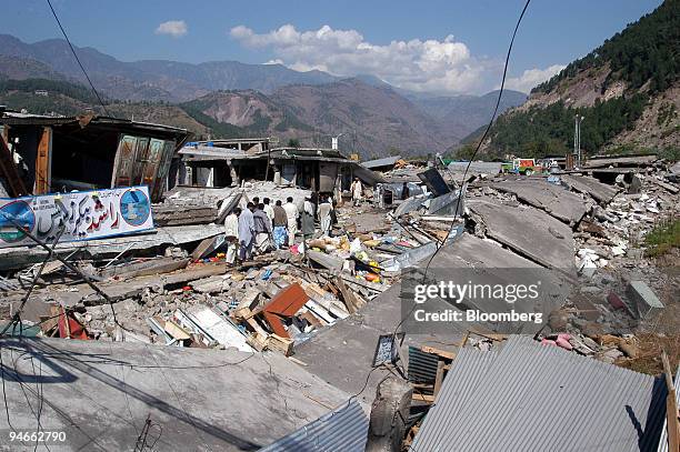 People pass through the debris of a ruined market in Balakot, Pakistan on Sunday, October 9, 2005 one day after a powerful earthquake struck. The...