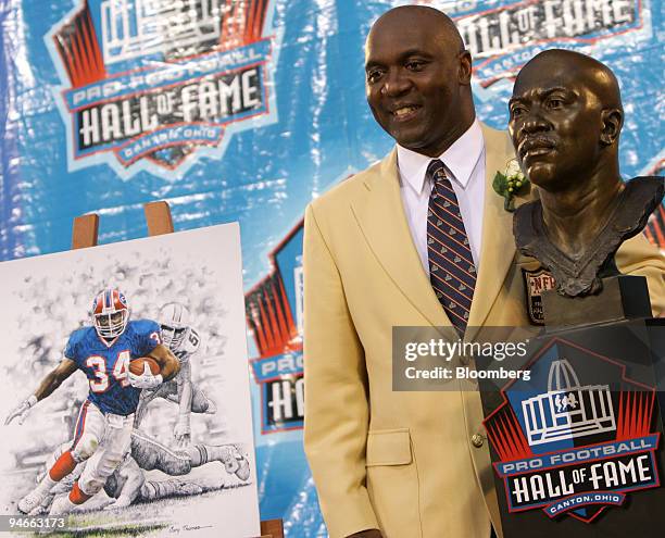 Thurman Thomas, former player of the Buffalo Bills, poses with a bust in his image after his induction into the Pro Football Hall of Fame Saturday in...