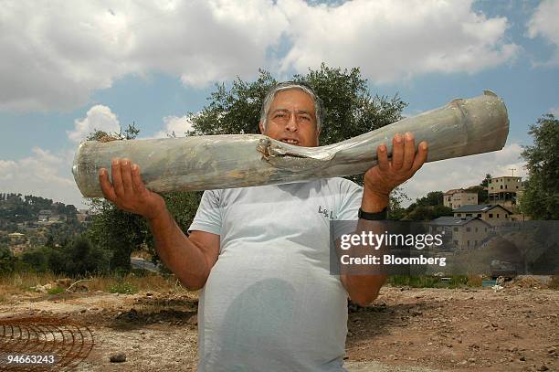 Man holds the remnants of a rocket that landed in an open area near Safed, in Upper Galilee, Israel, Friday, July 14, 2006. Israel pounded Hezbollah...