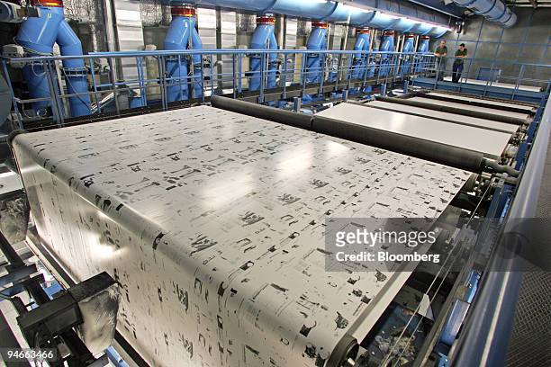 Workers observe the restart of a large rotogravure printing machine at the Prinovis printing plant in Nuremberg, southern Germany, on Tuesday, April...