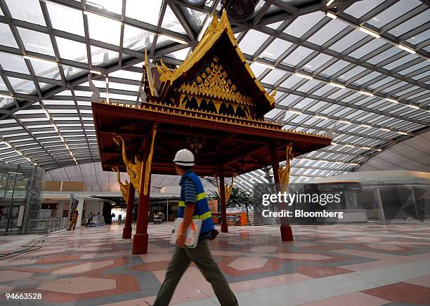 Construction worker passes a Thai Sala decorating the junction of three concours at Bangkok's new Suvarnabhumi, Golden Land, airport on Friday...