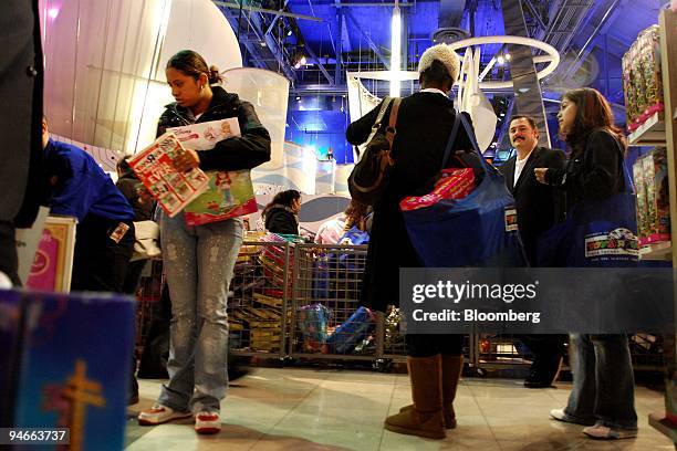 Ron Boire, president of Toys "R" Us Inc.'s North America unit, second from the right, poses as shoppers pass by in the company's Times Square store...
