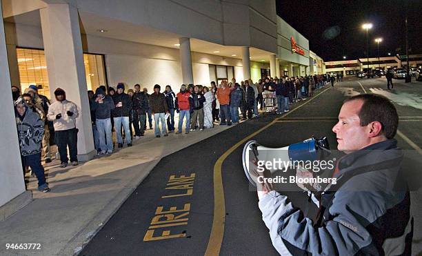 Micro Center manager Rich Huschling, right, speaks to a line of shoppers waiting outside a Micro Center store before their 6 AM opening in Columbus,...