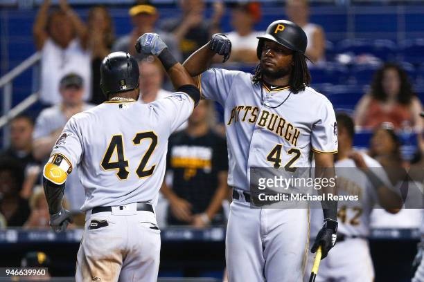 Starling Marte of the Pittsburgh Pirates celebrates with Josh Bell after hitting a solo home run in the ninth inning against the Miami Marlins at...