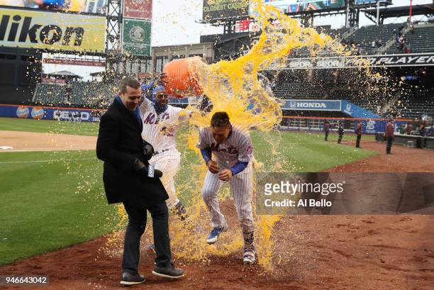 Wilmer Flores of the New York Mets is hit with a gatorade bath by teamate Yoenis Cespedes after he hit a walkoff home run in the ninth inning to win...
