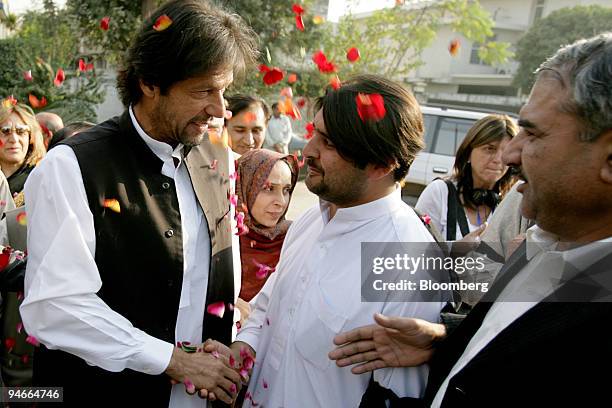 Imran Khan, left, chairman of Pakistan Tehreek-e-Insaf or Movement for Justice, greets supporters prior to a press conference in Islamabad, Pakistan,...