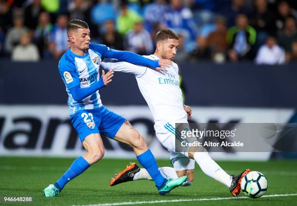 Sergio Ramos of Real Madrid competes for the ball with Maxime Lestienne of Malaga during the La Liga match between Malaga CF and Real Madrid CF at...