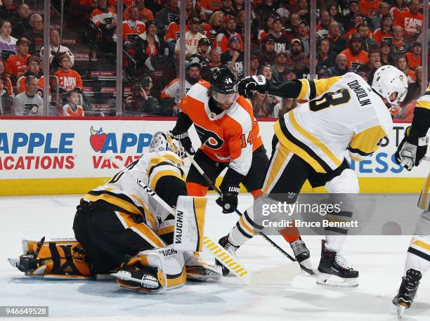 Matt Murray and Brian Dumoulin of the Pittsburgh Penguins defend against Sean Couturier of the Philadelphia Flyers during the second period in Game...