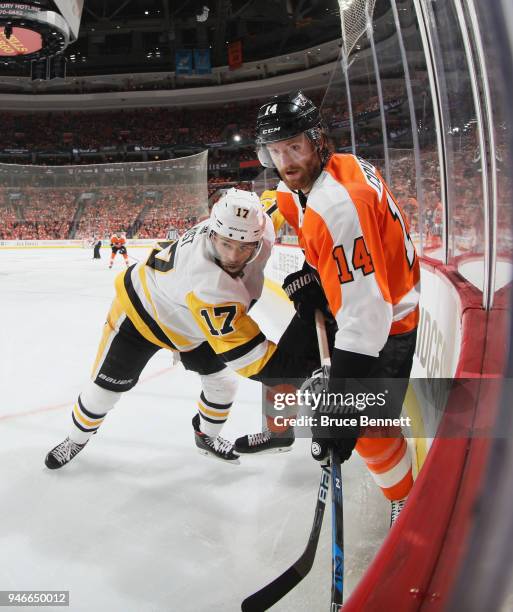 Sean Couturier of the Philadelphia Flyers is checked by Bryan Rust of the Pittsburgh Penguins during the second period in Game Three of the Eastern...