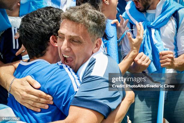 argentinian football fans embracing at football match - argentinian supporters stock pictures, royalty-free photos & images