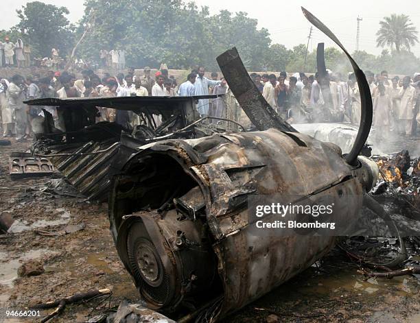 Smoke rises from the wreckage of a Pakistan International Airlines Fokker F-27 plane in Multan, Pakistan on Monday, July 10, 2006. The PIA turbo-prop...