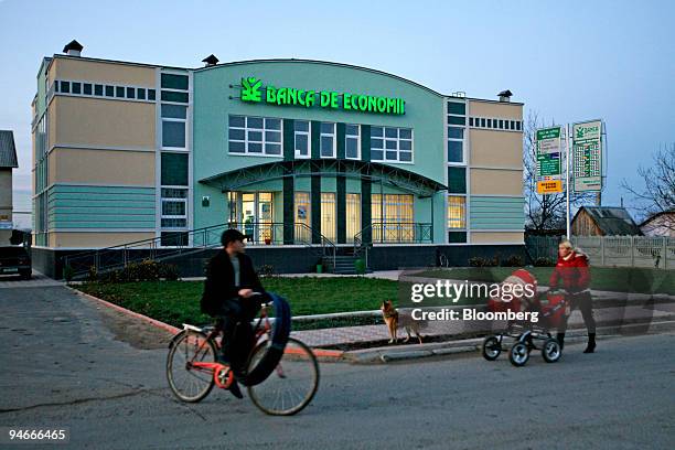 People walk and bike past an office of Banca de Economii S.A in Chisinua, Moldova, on Wednesday, Nov. 14, 2007. Transnistria is in a quandary: While...