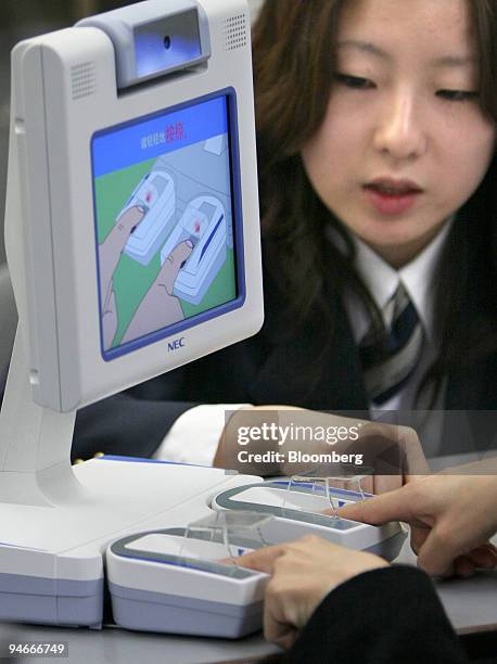 Foreigner places his fingers on a fingerprint reading device at the immigration control area of Narita International Airport in Chiba prefecture,...